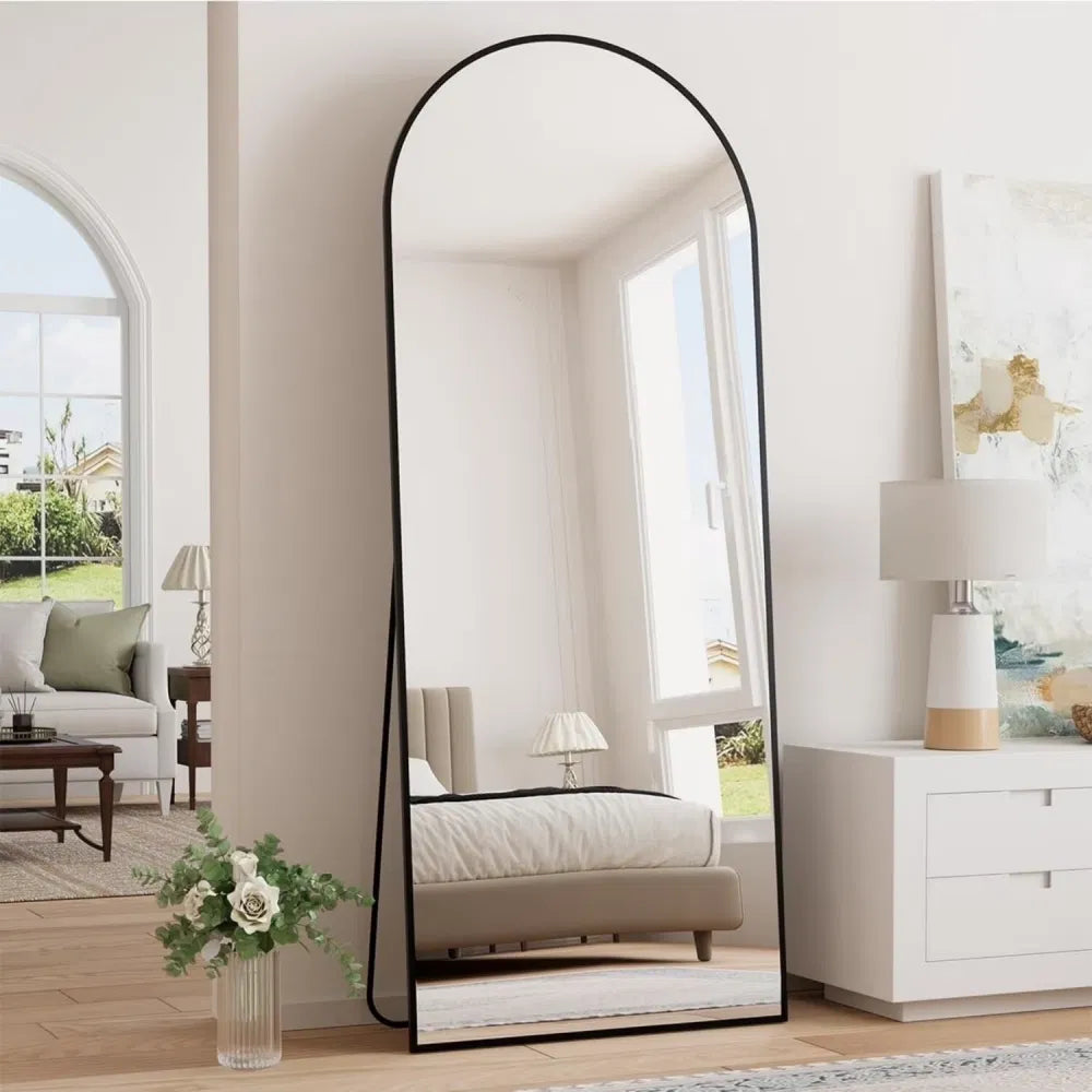 64x21 inch black arched full-length floor mirror in a bedroom